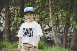 Menino De Camisa Branca E Boné Azul