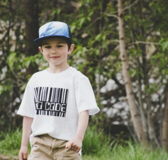 Menino De Camisa Branca E Boné Azul